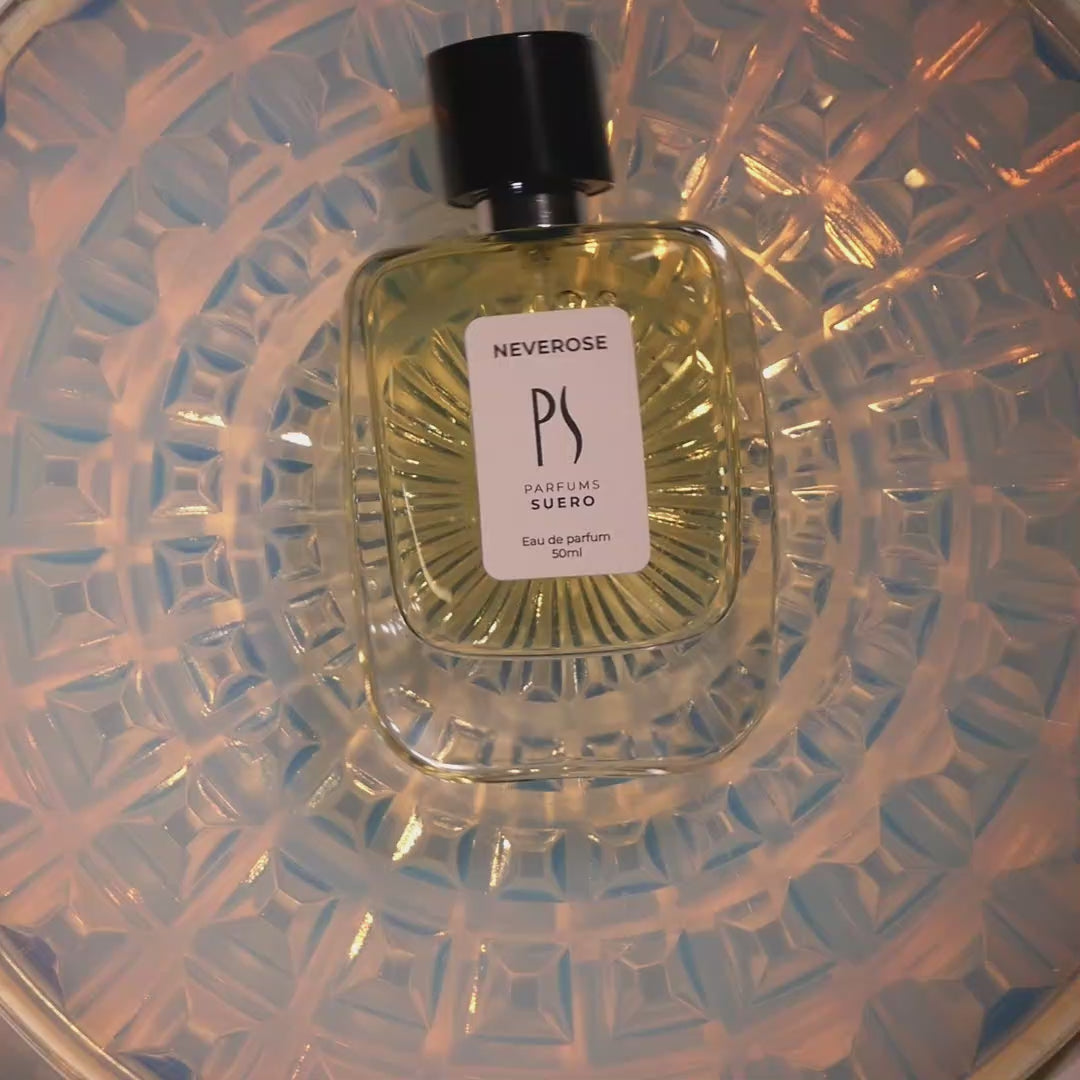 video du flacon de Neverose de la marque de Parfums SUERO, le flacon tourne sur un fond en verre opaline